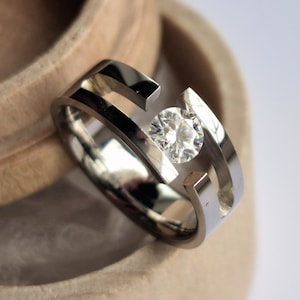 Titanium tension ring with round brilliant cut gemstone setting. Polished finish. Handmade and customizable.