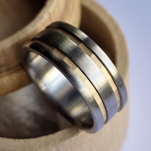 Anillo de titanio cepillado hecho a mano con canales de oro macizo facetado.