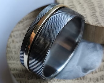 Stainless damascus steel, solid gold and titanium spinner ring. Handmade and customizable.