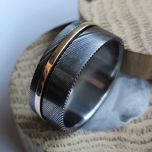 Bague spinner en acier damas inoxydable, or massif et titane. Fait main et personnalisable.