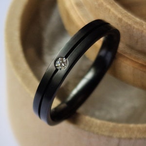 Black zirconium band with flush set gemstone. Minimalist stacking ring. Handmade and customizable.