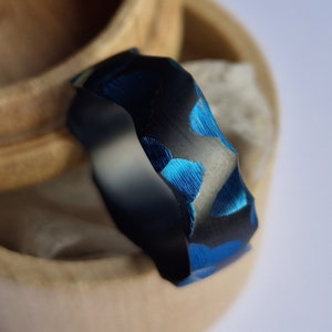 Black zirconium band with deep blue facets. Handmade and customizable.