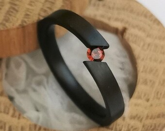 Brushed zirconium tension ring with round brilliant cut gemstone setting. Handmade and customizable.