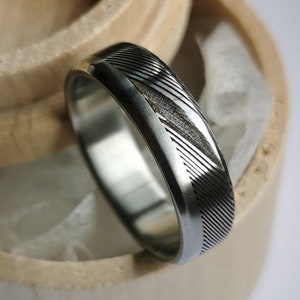 Bevelled stainless damascus steel and titanium ring. Handmade and customizable.
