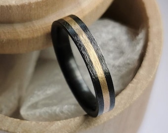 Black zirconium band with gold channel. Rough brushed finish. Handmade and customizable.