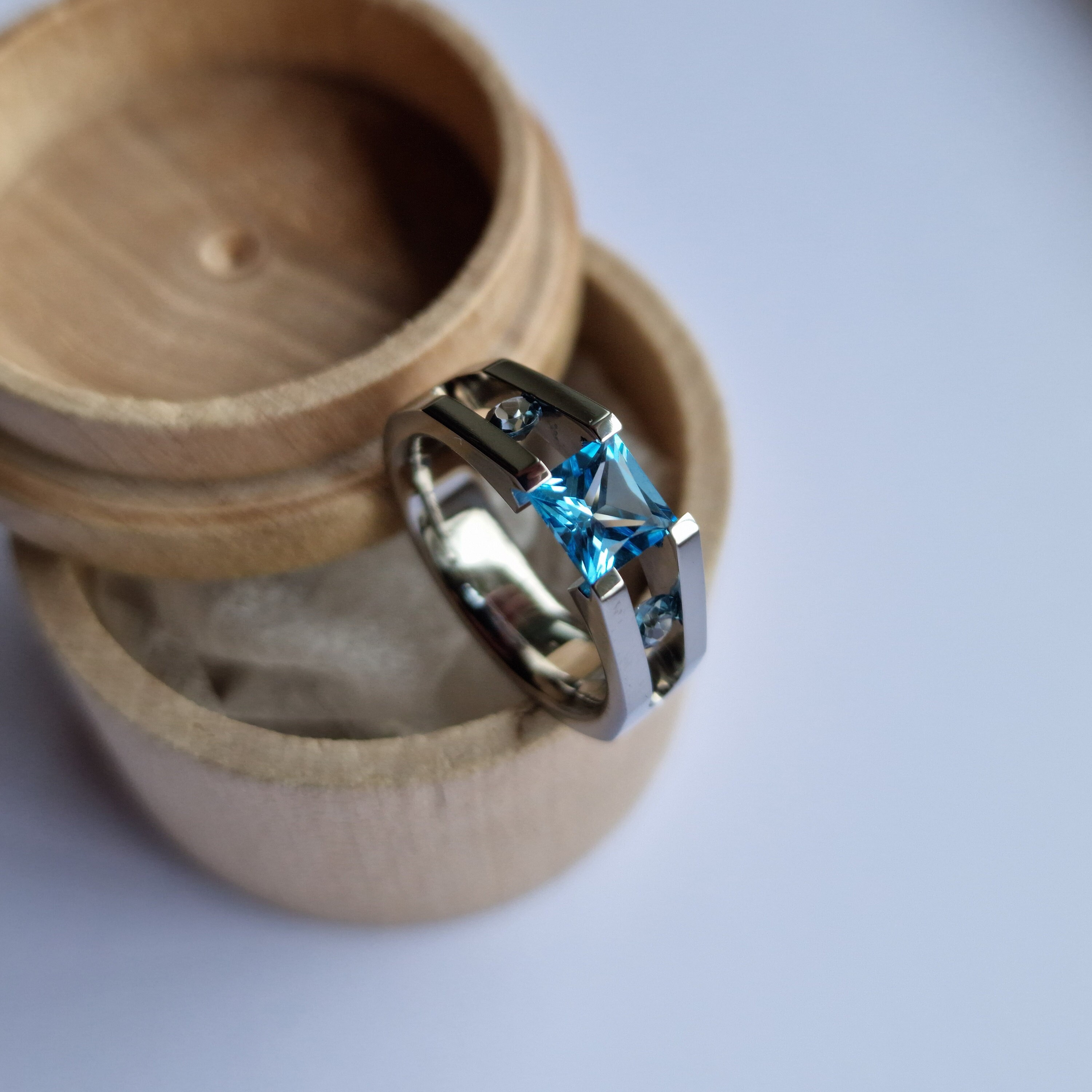 Anel tensor de titânio com pedras preciosas em lapidação princesa e pedras preciosas em lapidação brilhante. Acabamento polido. Feito à mão e personalizável.