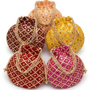May include: Five round drawstring pouches in peach, yellow, burgundy, red, and fuchsia. Each bag features a gold lattice pattern with embedded circular mirrors and small gold beads. The pouches have pearl-like beaded handles and drawstring closures.
