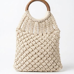 May include: A beige macrame tote bag with a wooden handle. The bag features a woven design and a circular wooden handle. The bag is made of a natural fiber material and is suitable for carrying various items.