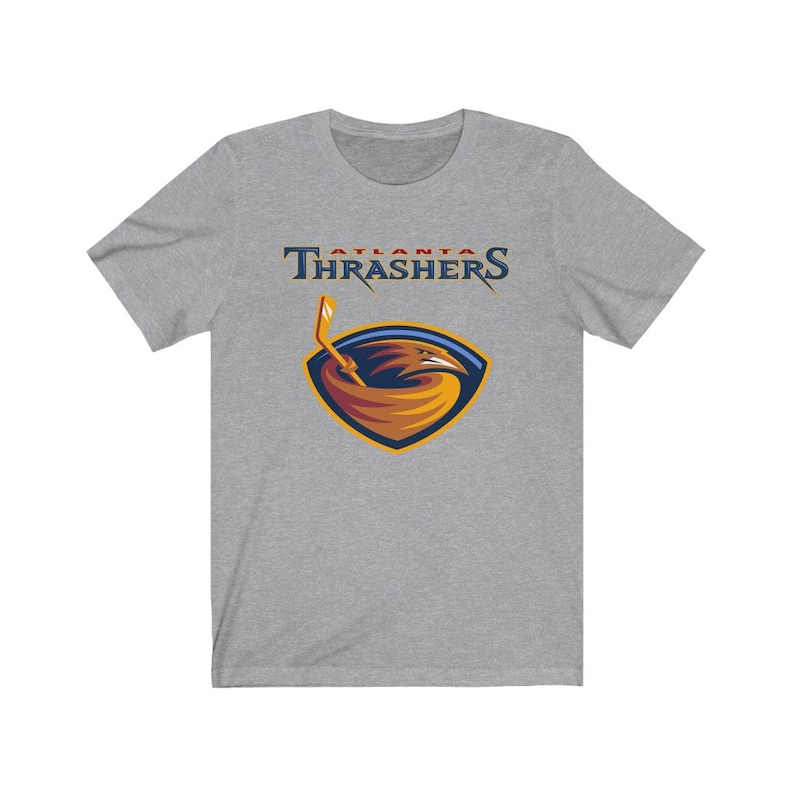 May include: A heather grey t-shirt with the Atlanta Thrashers logo. The logo features a red, orange, and yellow bird with a hockey stick in its beak. The text "Atlanta Thrashers" is above the logo.