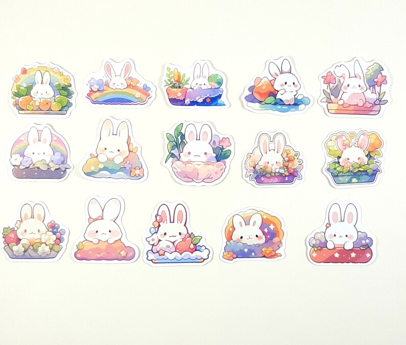 May include: A set of 15 stickers featuring cute white bunnies in various settings. The bunnies are surrounded by flowers, rainbows, and other whimsical elements. The stickers are perfect for adding a touch of whimsy to journals, laptops, or other surfaces.