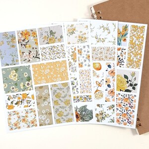 May include: A set of 24 floral patterned stickers featuring yellow, white, and green flowers on a white background. The stickers are arranged in a grid pattern and are perfect for adding a touch of whimsy to planners, journals, and other craft projects.