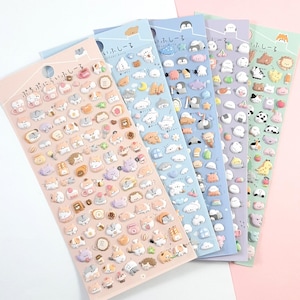 Puede incluir: Cuatro hojas de pegatinas coloridas con lindos animales de dibujos animados, comida y objetos. Las pegatinas son 3D y tienen un acabado brillante. Las hojas est&aacute;n etiquetadas en japon&eacute;s con el texto "kawaii stickers".