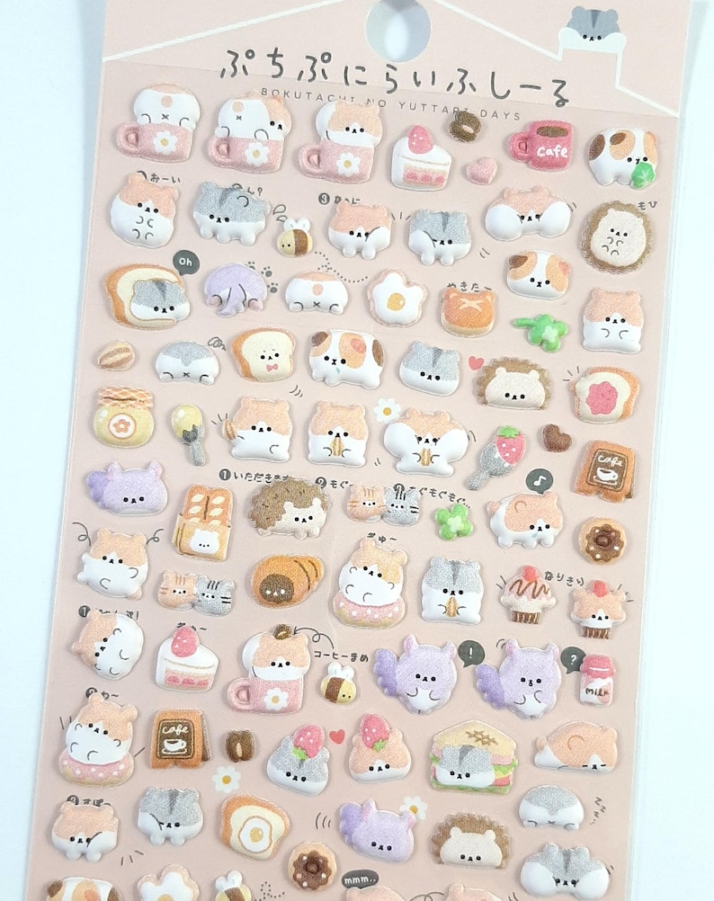 Puede incluir: Una hoja de pegatinas hinchadas con adorables animales de dibujos animados, comida y otros dise&ntilde;os lindos. Las pegatinas est&aacute;n sobre un fondo rosa con texto japon&eacute;s que dice "BOKUTACHTO YUTTARE DAYS" y "ぷちぷにらいふしーる".