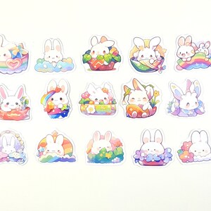 May include: A set of 12 colorful stickers featuring cute cartoon bunnies in various poses. The stickers are decorated with rainbows, flowers, and hearts.