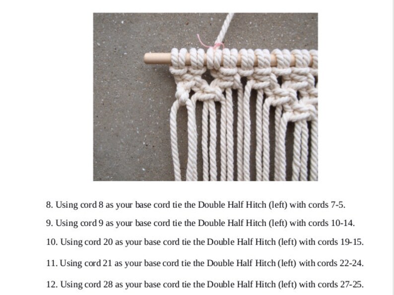 以下が含まれることがあります： 白い紐が結び目模様に結ばれたマクラメの壁掛けのクローズアップ。紐は木製の棒に結ばれています。