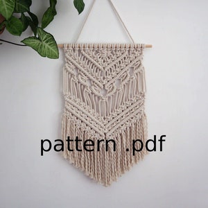 May include: A beige macrame wall hanging with a geometric pattern and fringe. The hanging is attached to a wooden dowel rod. The text "pattern.pdf" is visible at the bottom of the image.