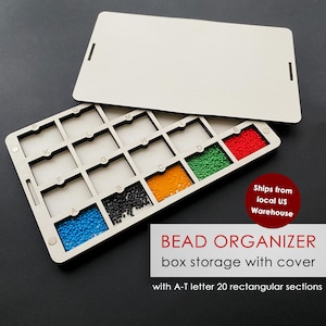 May include: A wooden bead organizer with a removable lid. The organizer has 20 rectangular sections labeled A-T, each filled with colorful beads. The beads are blue, black, orange, green, and red. The text "BEAD ORGANIZER box storage with cover" is visible.