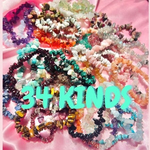 Pode incluir: Uma coleção de inúmeras pulseiras de pedras lascadas em uma grande variedade de cores, incluindo roxo, laranja, verde, azul e transparente, dispostas em uma pilha. O texto 34 KINDS está sobreposto em letras ciano brilhantes sobre as pulseiras.