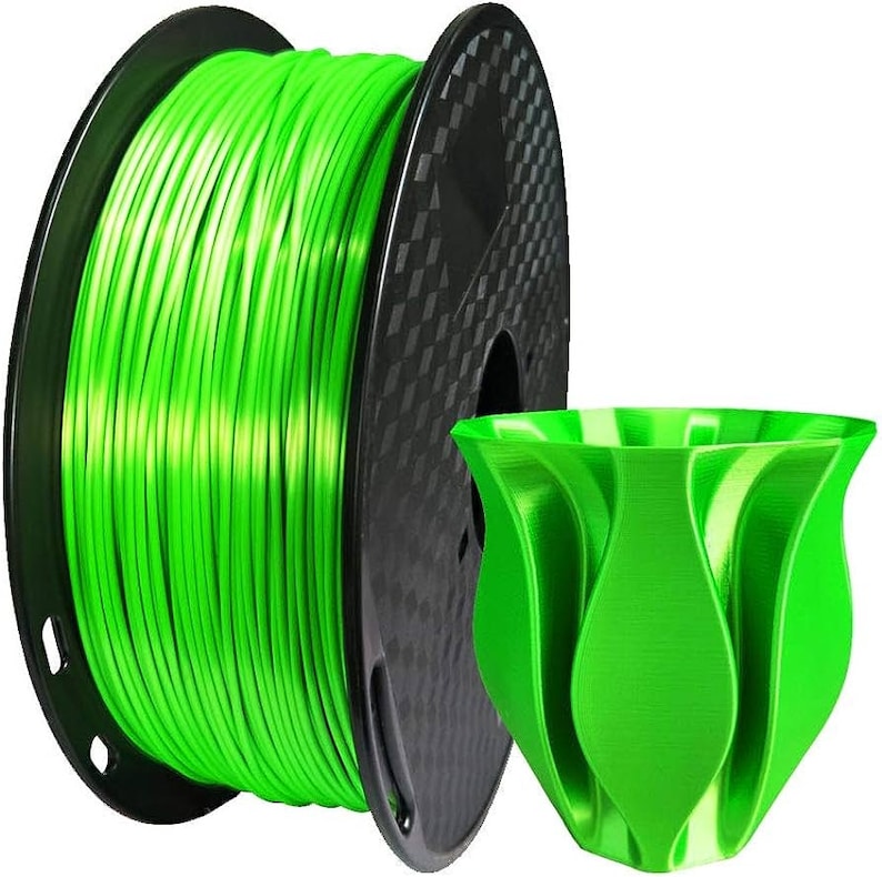 Pu&ograve; includere: Un rotolo di filamento verde brillante per la stampa 3D, con un oggetto stampato dello stesso colore. L'oggetto &egrave; un vaso con un design unico e organico.