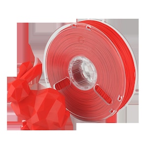 Pu&ograve; includere: Un rotolo di filamento rosso per la stampa 3D. Il filamento &egrave; avvolto attorno a un rotolo di plastica trasparente con un foro centrale. Una statuetta di coniglio rossa stampata in 3D &egrave; in primo piano.