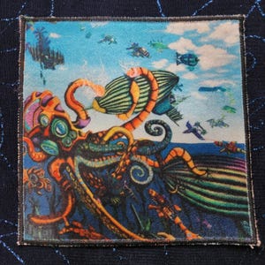 May include: A colorful, psychedelic patch featuring an octopus with multiple tentacles, a large blimp, and other flying objects in the background. The patch is made of fabric and has a stitched border.
