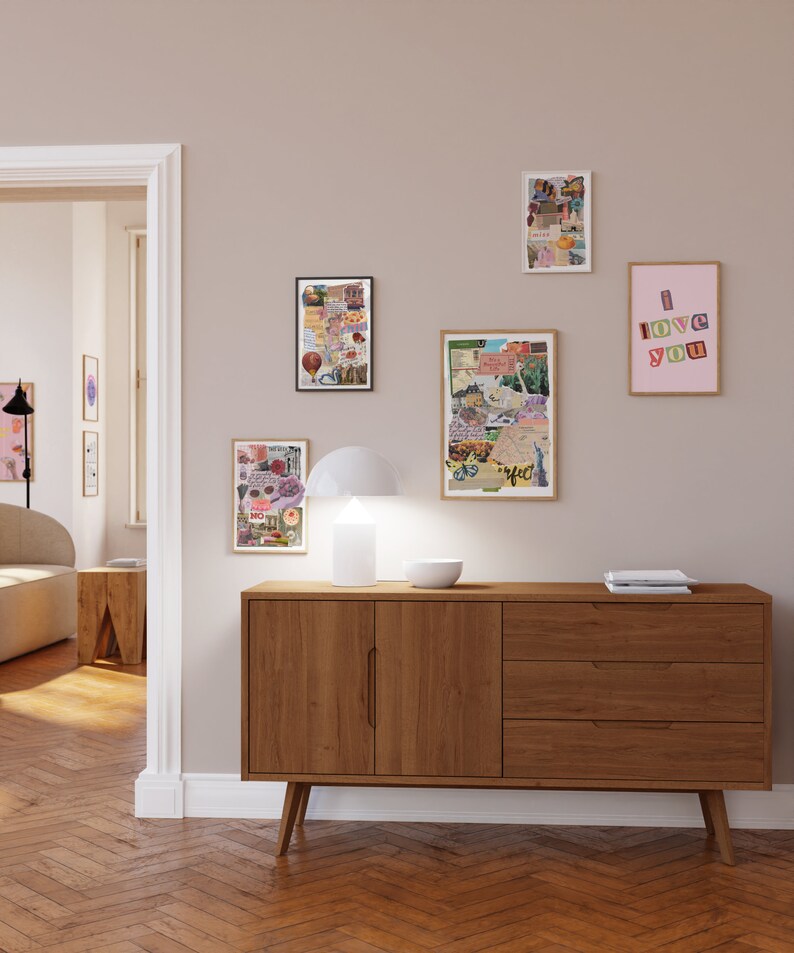 May include: A wooden dresser with three drawers and two doors. The dresser is in a room with a light brown wood floor and white walls. There are several framed pictures on the wall, including one with the words "I love you" in colorful letters.