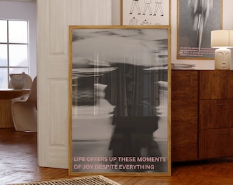 May include: A black and white photograph in a wooden frame with the text "Life offers up these moments of joy despite everything".