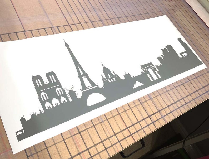 Puede incluir: Una silueta gris del horizonte de Par&iacute;s, con monumentos emblem&aacute;ticos como la Torre Eiffel, la Catedral de Notre Dame y el Arco del Triunfo.