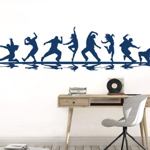 May include: A dark blue wall decal featuring a horizontal row of eight silhouettes of people in various dynamic dance poses. Each figure is depicted in motion, with a mirrored reflection effect appearing directly beneath the line of dancers.