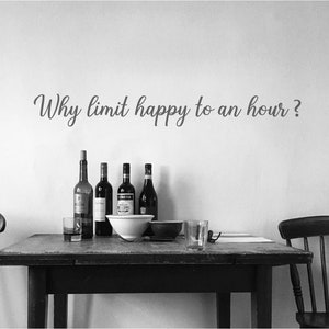 May include: A monochrome image showing a table with wine bottles, a glass, and a bowl. The text "Why limit happy to an hour?" is on the wall above. The scene suggests a relaxed dining setting.