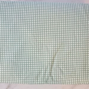 May include: A green and white gingham fabric with a small checkered pattern.