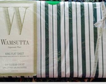 May include: A white king-sized flat sheet with green stripes. The sheet is packaged and labeled with the Wamsutta Supercale Plus brand name. The label also states that the sheet is 200 thread count and made of 50% cotton and 50% polyester.