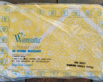 May include: A yellow and white floral patterned sheet in a plastic bag. The bag has the Wamsutta Ultracale brand name and the text "No Ironing Necessary". The sheet is labeled "One Sheet Standard Double Fitted".