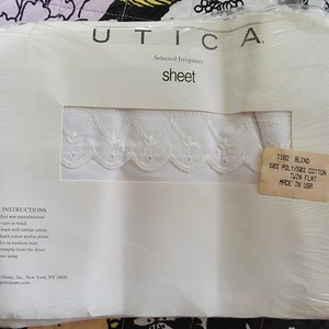 May include: White sheet packaging with a white lace trim. The packaging has the text "UTICA" and "Selected Irregulars sheet" printed on it. The packaging also has a label that says "T182 BLEND 50% POLY/50% COTTON TWIN FLAT MADE IN USA".