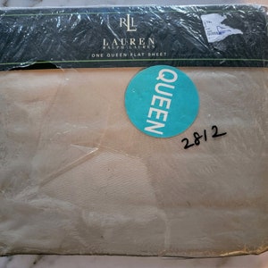 May include: A beige queen-sized flat sheet in a plastic package with a blue sticker that says "QUEEN" and a handwritten price tag that says "28/2". The package has a black label that says "RL LAUREN RALPH LAUREN ONE QUEEN FLAT SHEET".