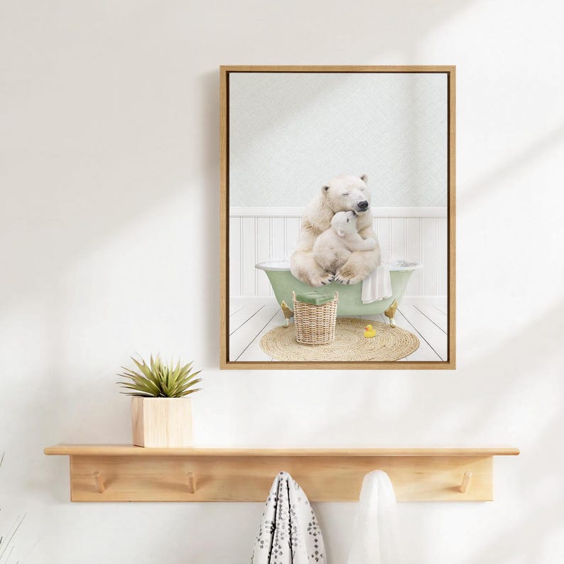 A framed image of a polar bear sitting in a bathtub, with a baby polar bear next to it, is hanging on a white wall above a wooden shelf.