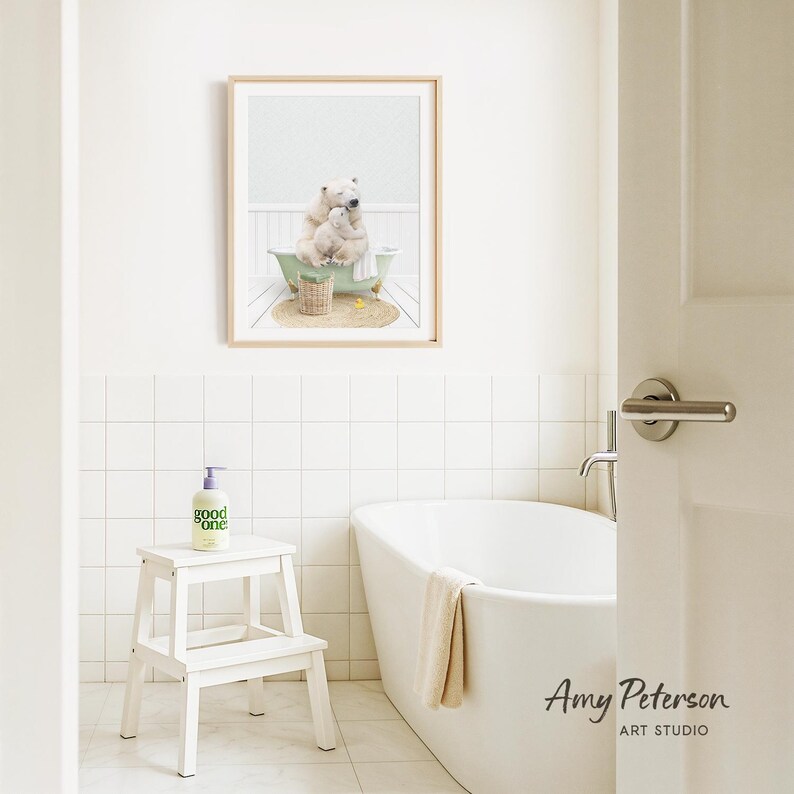 A framed image of a polar bear sitting in a bathtub is displayed on the wall above a white bathtub in a bathroom.