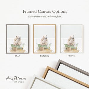 three framed canvas options, each featuring a white bear in a bathtub. The options include a gray frame, a natural frame, and a white frame. The text above the images reads " framed Canvas Options" and "Three frame colors to choose from...".
