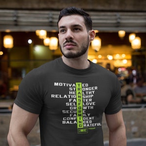 May include: Dark gray t-shirt with the word "STRONG" in green and white, composed of words like "Motivated", "Healthy", and "Grateful". The shirt also has the text ":ME #hashtag".