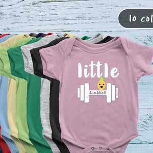 May include: A collection of baby onesies in various colors, including gray, red, and green. The pink onesie features the text "little dumbbell" with a pineapple graphic. The image shows 10 color options.