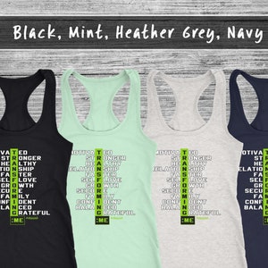 May include: Four racerback vests in black, mint green, heather grey, and navy blue. Each vest displays a vertical list of motivational words in white and green, including "Motivated", "Stronger", and "Grateful".