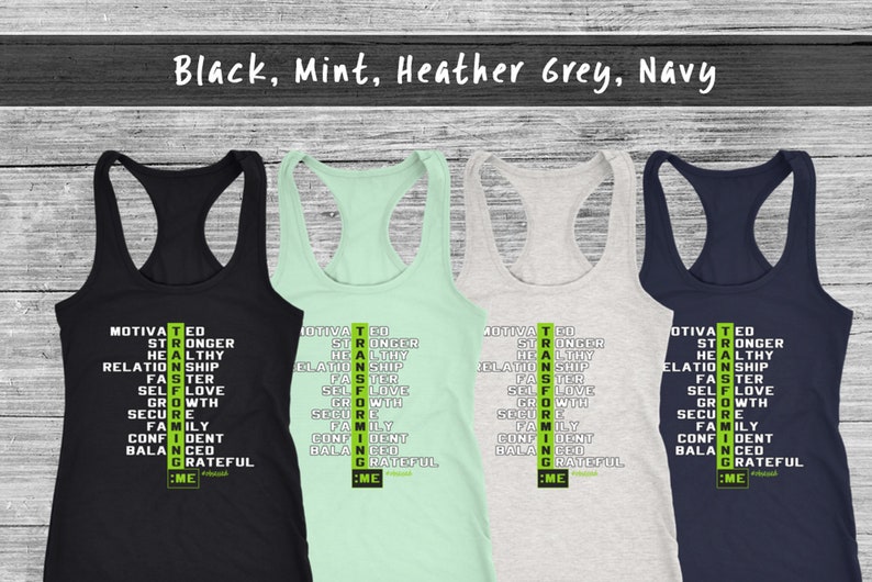 May include: Four racerback vests in black, mint green, heather grey, and navy blue. Each vest displays a vertical list of motivational words in white and green, including "Motivated", "Stronger", and "Grateful".
