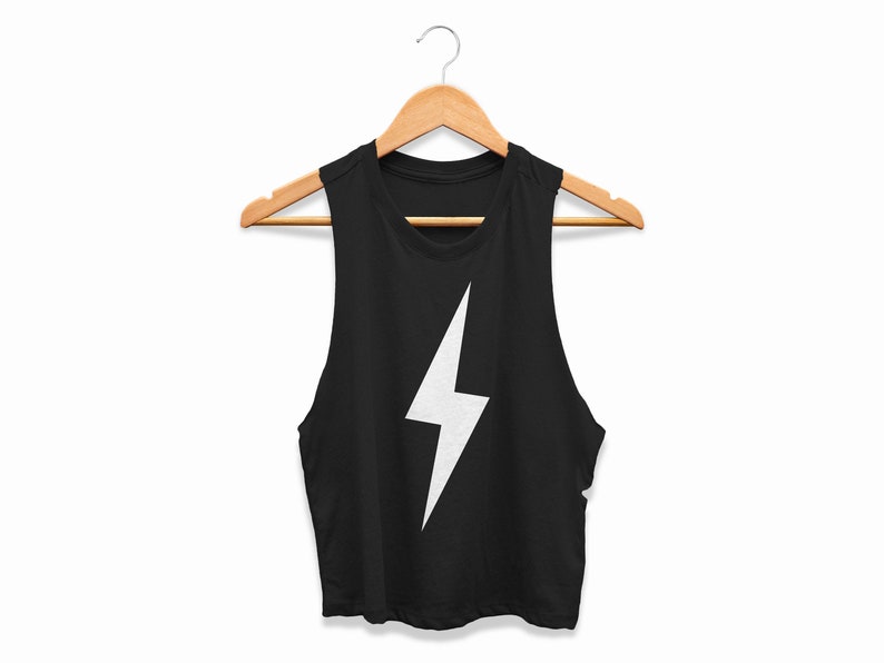 May include: Black sleeveless crop top with a white lightning bolt design. The top is displayed on a wooden hanger. The background is white. The tank top is made of a soft material.