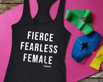 May include: Black racerback vest with the words "FIERCE FEARLESS FEMALE" in white block letters. The vest is on a pink yoga mat, with green, blue, and yellow resistance bands. The text "#obsessed" is below the main text.