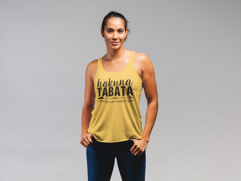 May include: Mustard yellow tank top with the text "hakuna TABATA" in black script. Below the text is the phrase "it means there's four minutes to kill!" in a smaller font. The tank top has a racerback design.