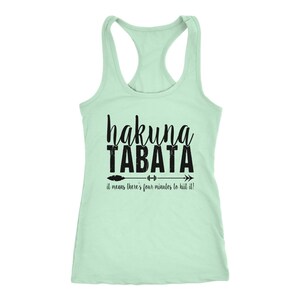 May include: A light green racerback tank top with the words "hakuna TABATA" in black script. Below the text is an arrow with a barbell and the phrase "it means there's four minutes to hiit it!"