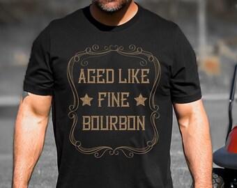 May include: Black t-shirt with a gold graphic that says "Aged Like Fine Bourbon" with two stars on either side of the word "Fine".