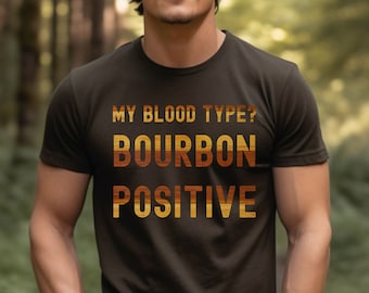 May include: A brown t-shirt with the text "MY BLOOD TYPE? BOURBON POSITIVE" in a vintage style font.