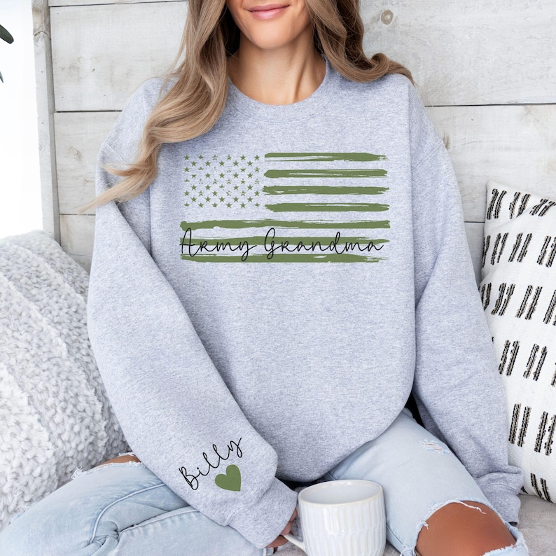 May include: Gray sweatshirt with a green and white American flag design and the text "Army Grandma". The left sleeve has the text "Billy" with a heart.