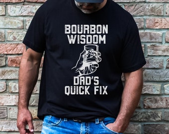 May include: Black t-shirt with white text that reads "Bourbon Wisdom Dad's Quick Fix". A hand holding a glass of bourbon with ice is pictured above the text.